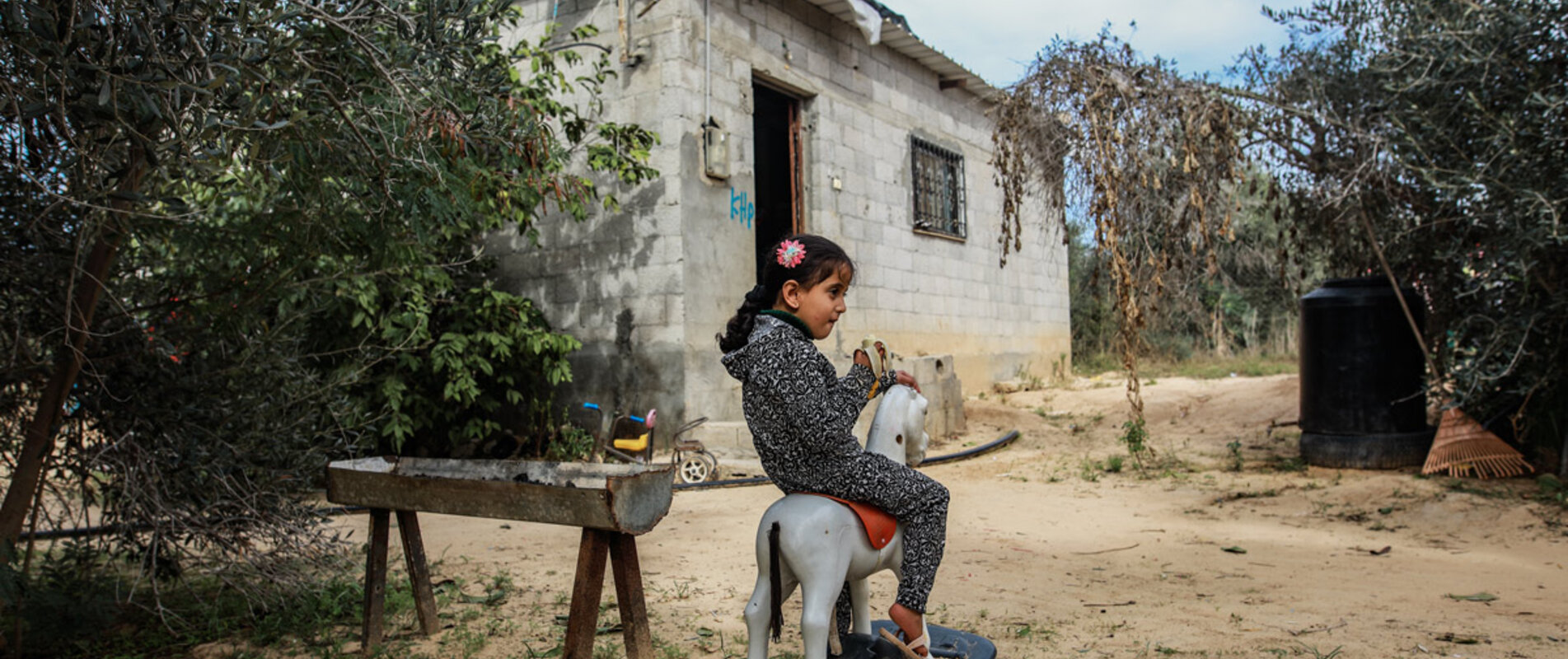 לין אבו הג׳רס בת הארבע משחקת בחזית ביתה בח׳אן יונס, ברצועת עזה, אחרי שהחלימה מתת־תזונה. צילום: מוחמד א־ריף עבור שירותי הסיוע הקתוליים