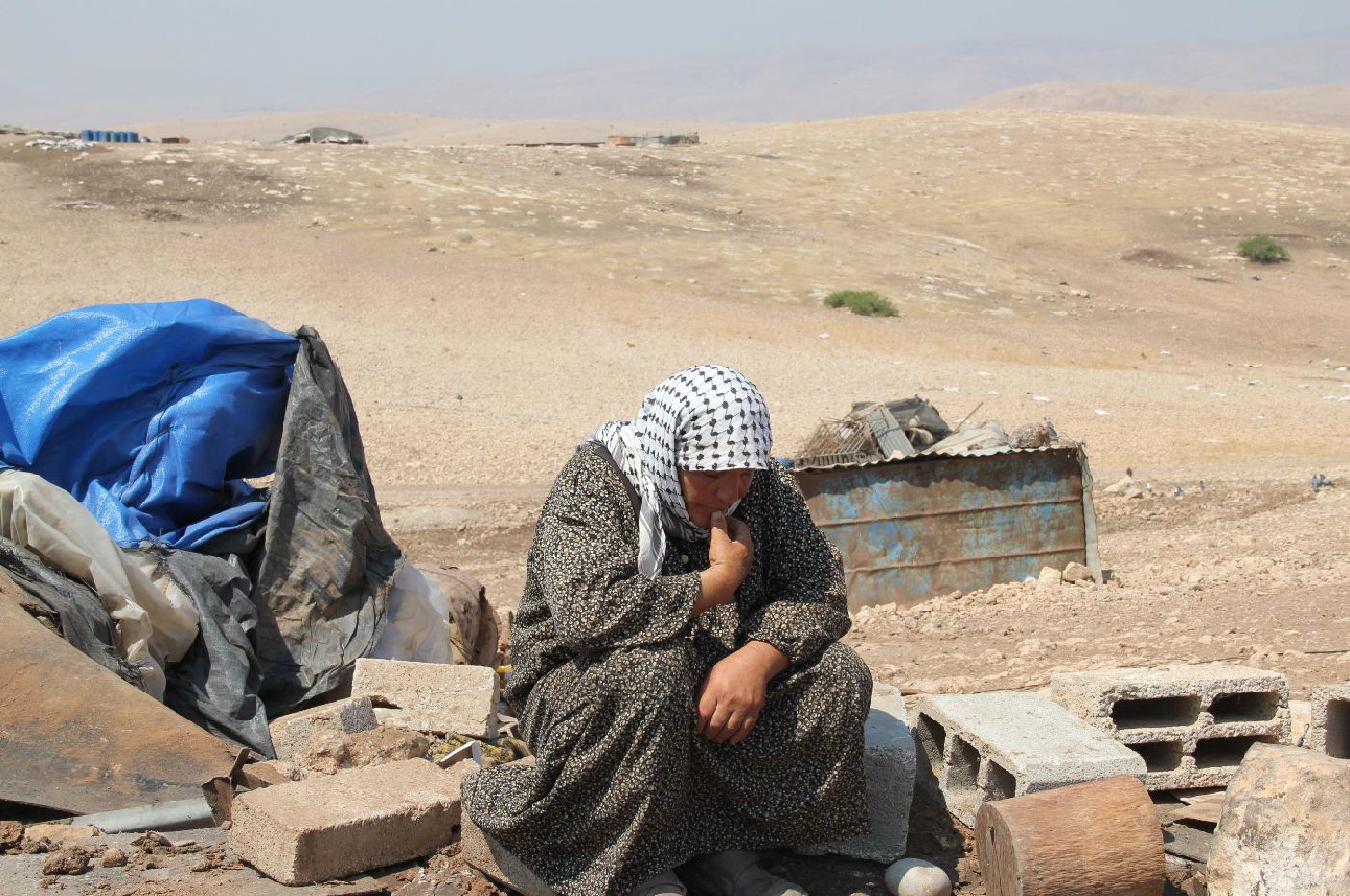 Palestinian woman sits on the rubble of her demolished home in Al Hadidiya. Photo by H. Minch, EAPPI, June 2011