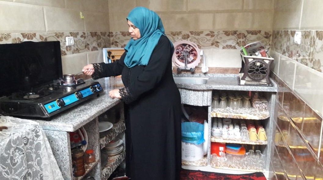 Ibtisam preparing coffee in her new kitchenאבתיסאם מכינה קפה במטבח החדש שלה.