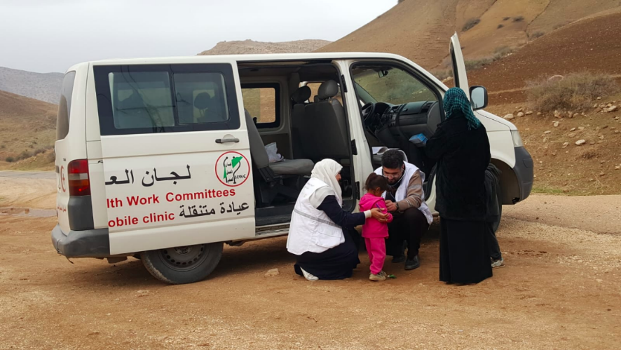 A doctor and nurse assistant with the Union of Health Work Committees providing assistance to a child the Al Maleh area. Credit: WHO/Alice Plate