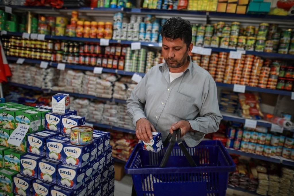 محمود يشتري المواد الغذائية من سوبرماركت محلي.