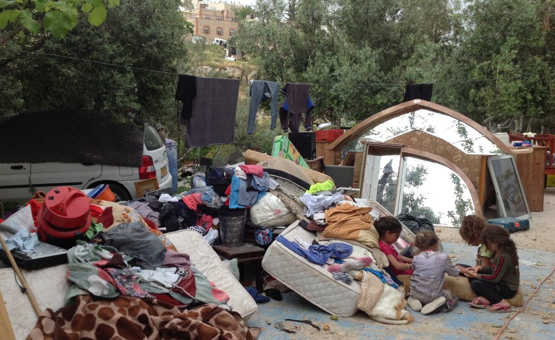 Children of Qusay and Anas Burqan sitting by their belongings after their homes were demolished, Wadi Yasul. © Photo by OCHA