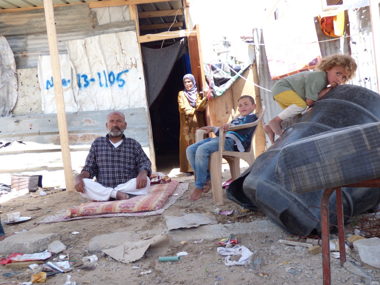 أبو محمد وأسرته بجوار مأواهم المؤقت في بيت حانون، أيار/مايو 2015 © - تصوير مكتب الأمم المتحدة لتنسيق الشؤون الإنسانية