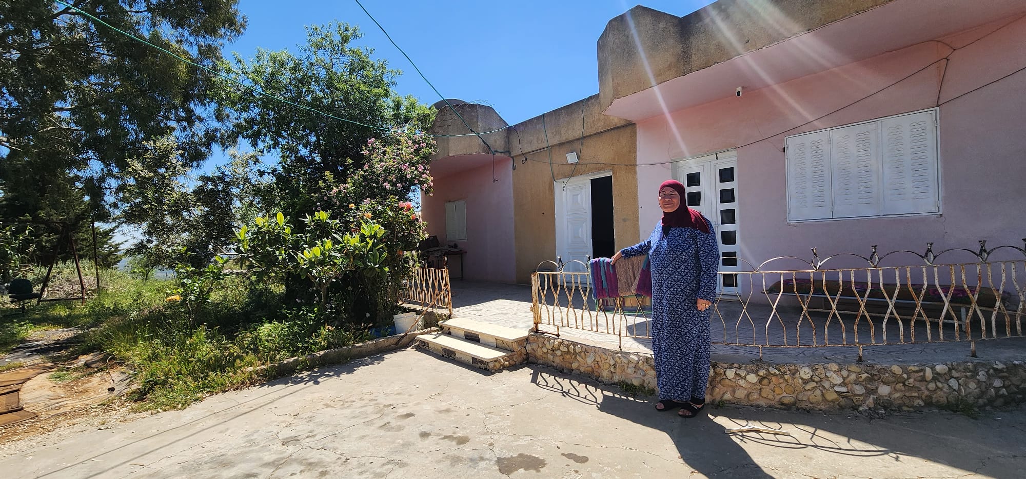 Umm Saleh Shreteh standing in front of her house in Al Mazra’a Al Qibliya, the central West Bank. Photo by OCHA