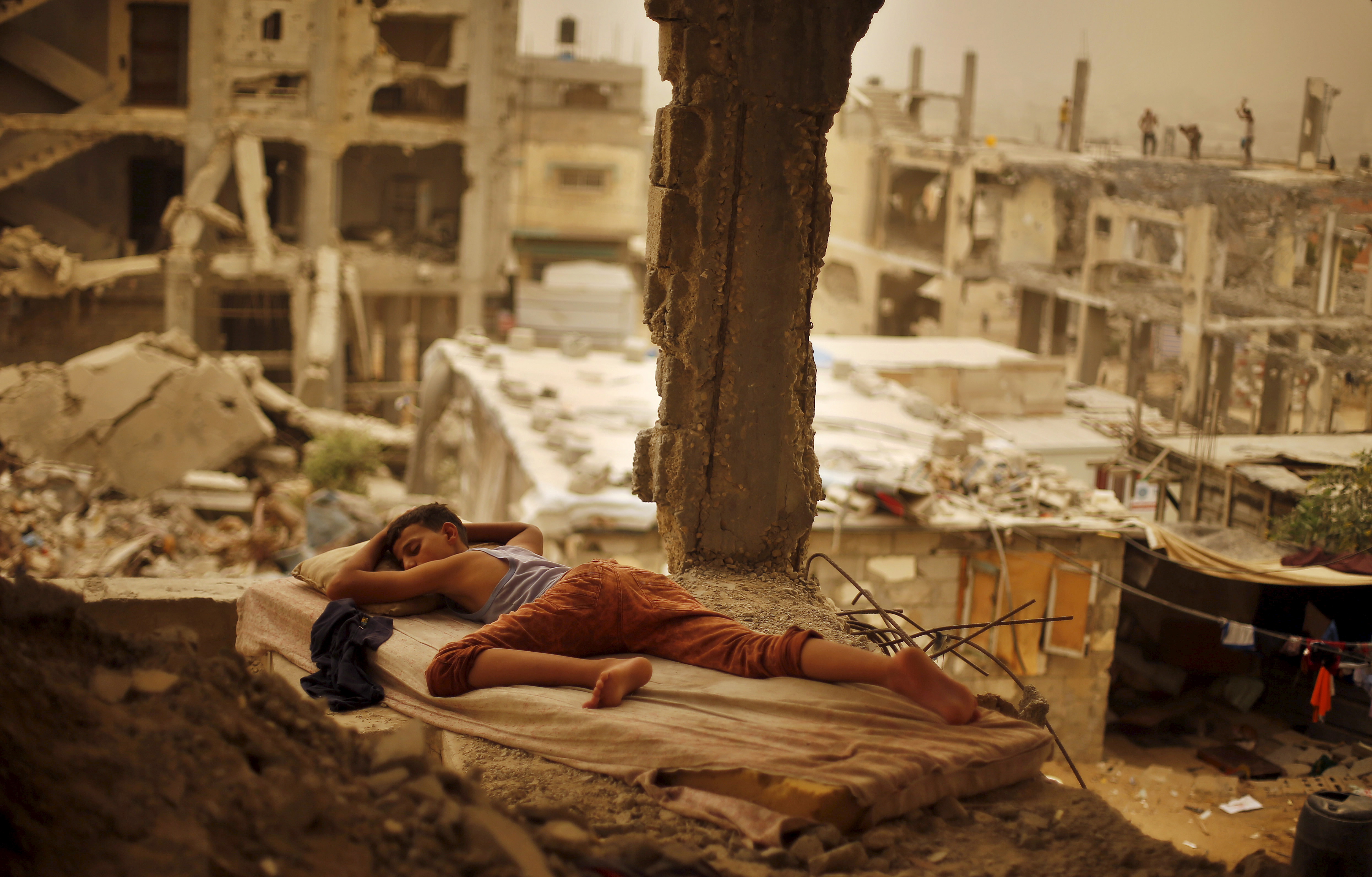 Palestinian boy sleeping inside his destroyed home in the Shuja’iyeh neighbourhood of Gaza City, September 2015. © Photo by Suhaib Salem