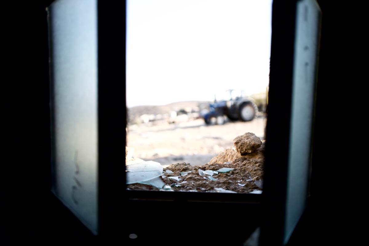 Mahmoud's tractor, as seen through a broken window in Um Fagarah following a settler attack on the village. Photo by Manal Massalha for OCHA.