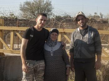 Hiyam Ahmad Jumaa, and her two sons in front of “Barrier Gate 105”, outside of Beit Surik village (Ramallah), 31 October, 2019. ©  Photo by OCHA