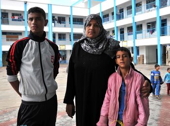 Afaf and two of her nine children at the UNRWA Collective Centre. Photo by UNRWA