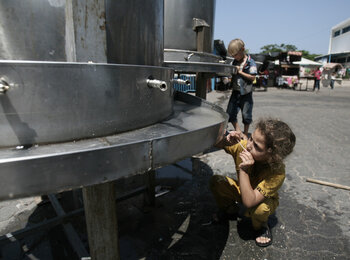 IDP child at WFP food distribution in UNRWA collective shelter, Rafah, August 2014. Photo WFP/Eyad al Baba