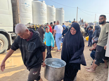 نازحون في منطقة المواصي يحضرون الماء الذي نقلته الصهاريج، 17 أيار/مايو 2024. تصوير مكتب الأمم المتحدة لتنسيق الشؤون الإنسانية/ياسمينا غيردا 