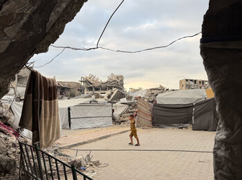 A Palestinian boy playing in between makeshift shelters set up next to unsafe war-damaged buildings at risk of collapse in the Gaza Strip, October 2026. Photo by UN News