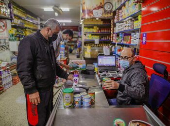 Using an e-voucher, Mohammed selects food and living supplies for his family. Photo by Mohamed Reefi for CRS