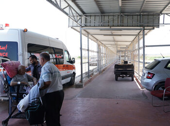 Old man with a cancer patient exiting to Istishari Arab Hospital at Ramallah to receive medical treatment.