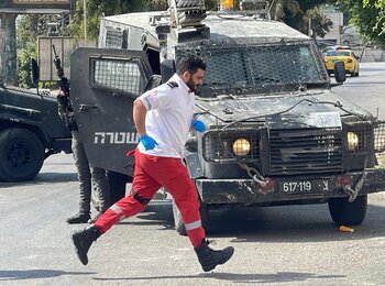 A medic with the Palestine Red Crescent Society rushing to treat wounded people in Nablus city during an Israeli operation, 27 August 2025. Photo by Abdullah Bahash