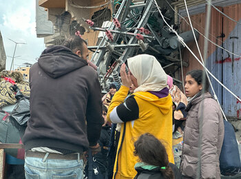 People standing in a destroyed urban area of Khan Younis during another wave of displacement toward Rafah as intense hostilities continue and following new evacuation orders for large residential areas. Photo by OCHA/Olga Cherevko, 29 January 2024