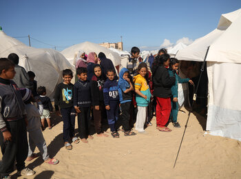 ילדים בכניסה למרפאה באוהל ברפיח, ממתינים בתור לבדיקות סקר לתת-תזונה ולהפנייה לטיפול, ככל שיידרש. צילום: יוניסף / אל-באבא