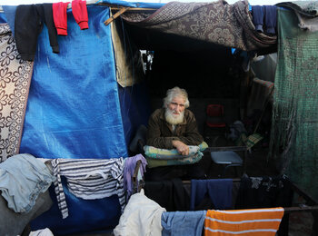 The approximately 111,500 older people in Gaza are among those most at risk of hunger, dehydration, illness, injury, and death, HelpAge reports. A displaced older Palestinian in a makeshift shelter. Photo by UNRWA