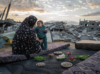 Um Omar, a Palestinian from Gaza, breaking the Ramadan fast out in the open, surrounded by debris. Photo by WFP