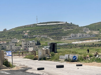 A Palestinian walking by a closed iron gate installed by Israeli forces to block a road leading to Al Fawwar camp, in the southern West Bank. Photo by OCHA