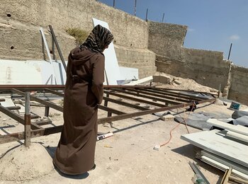امرأة فلسطينية تقف أمام منزلها المهدوم في منطقة جبل المكبّر بالقدس الشرقية. تصوير مكتب الأمم المتحدة تنسيق الشؤون الإنسانية