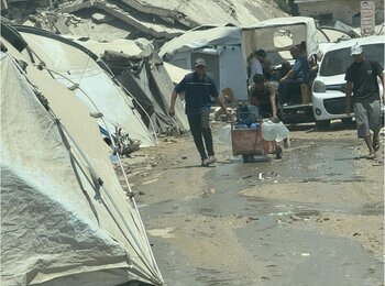 People carry drinking water at a displacement site in central Gaza. Without more fuel to power back-up generators, water extraction and desalination could soon grind to a halt. Photo by OCHA/Olga Cherevko