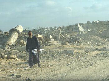 رجل فلسطيني يسير في منطقة مدمّرة وسط قطاع غزة. تصوير مكتب الأمم المتحدة لتنسيق الشؤون الإنسانية/أولغا تشيريفكو