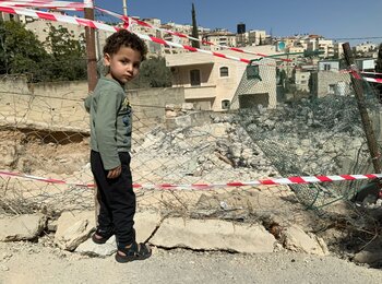 A displaced Palestinian boy next to what remains of his home that Israeli authorities forced his parents to demolish on 20 October, At Tur, East Jerusalem. Photo by OCHA