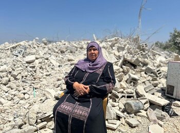 A Palestinian woman sits on the rubble of a building she nearly finished constructing when Israeli forces demolished it in Rafat village, west of Salfit. Photo OCHA.
