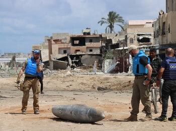 A UN team inspects an unexploded 1,000-pound bomb lying on a main road in Khan Younis. Photo: OCHA/Themba Linden.