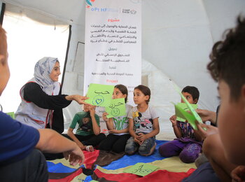 AWDA team member providing psychosocial support to children in Gaza, 2023. Photo by AWDA. (Sara and her children are not pictured.)