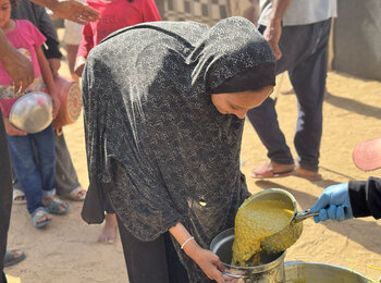 Food distribution at a community kitchen in Dier al Balah