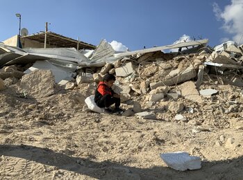 A Palestinian child sitting on the rubble of his families demolished house in Jabal Al Mukkabir, East Jerusalem. Photo by OCHA
