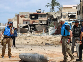 A UN team inspects an unexploded 1,000-pound bomb lying on a main road in Khan Younis. Photo: OCHA/Themba Linden.
