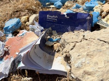 ספר שניזוק ונמצא על הארץ לאחר הריסת בית הספר בעין סאמיה, הגדה המערבית.