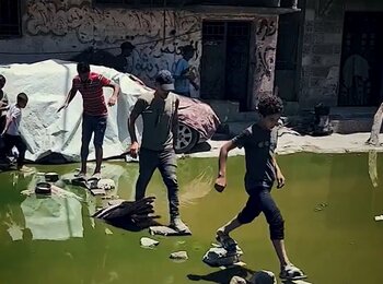 Children navigate a sewage-filled street in Gaza. Photo by UNICEF 