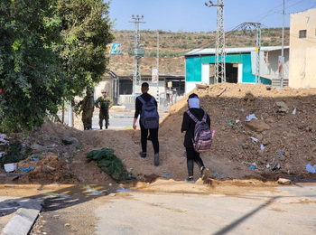 School children crossing a physical obstacle staffed by Israeli soldiers in Deir Sharaf, northern West Bank. Photo by Asef Nofal, 17 October 2022