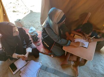 Eight-year-old Ibrahim while using his customized slant board to study, September 2025. Photo by EducAid