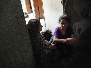 عبير النمنم وبناتها يجلسن في شرفة منزلهن في مخيم الشاطئ للاجئين، غزة، أيار/مايو 2017. تصوير مكتب تنسيق الشؤون الإنسانية.