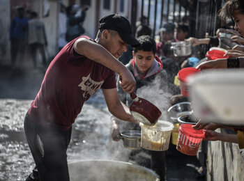    A volunteer distributes food to people in Rafah, southern Gaza. At least 576,000 people in Gaza – one-quarter of the population – face catastrophic levels of food insecurity and are at risk of famine. Photo by UNICEF/Abed Zagout 