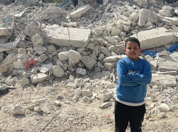 فتى فلسطيني يقف أمام منزله الذي كان قيد الإنشاء ولكن هدمته السلطات الإسرائيلية بحجة افتقاره إلى رخصة بناء صادرة عن إسرائيل في بيت أُمَّر. تصوير مكتب الأمم المتحدة لتنسيق الشؤون الإنسانية، 14 تشرين الثاني/نوفمبر 2024