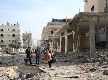 More people are reported killed, injured or missing across the Gaza Strip, with intense fighting continuing around hospitals, as most of the population is displaced and the humanitarian community unable respond to their needs. Picture of men walking through a devastated street in Gaza, by WHO