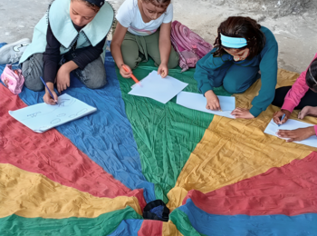Tala and other children drawing in a temporary learning space in 2025. Photo by NRC. 