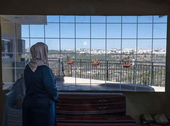 Nadia As Seifi looking out her window in Al Walaja (Bethlehem); her home is at risk of being demolished by the Israeli authorities.