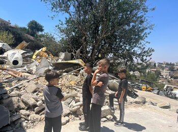 Children standing next to a demolished car-painting workshop in Dura Al Qar’a, Ramallah governorate. Destroyed for lacking an Israeli building permit, the structure was the source of livelihood for a family of nine. Photo: OCHA