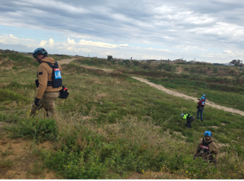 Explosive ordnance disposal officers inspecting an agricultural field in Sheikh Ajleen area for potential hazards. Photo by UNMAS
