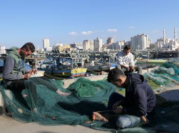  Palestinian fishers preparing their nets on the shore of Gaza. December 2018. © Photo by OCHA