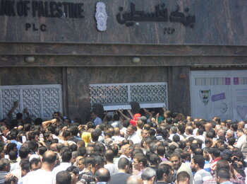 People queuing at the ATM at the Bank of Palestine. Rimal area, Gaza. January 2015. Photo by OCHA