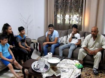 Ghaleb Abu Hadwan, a 63-year-old Palestinian from Sur Bahir, sitting in his living room with family members a few days before the demolition, July 2019. Photo by OCHA