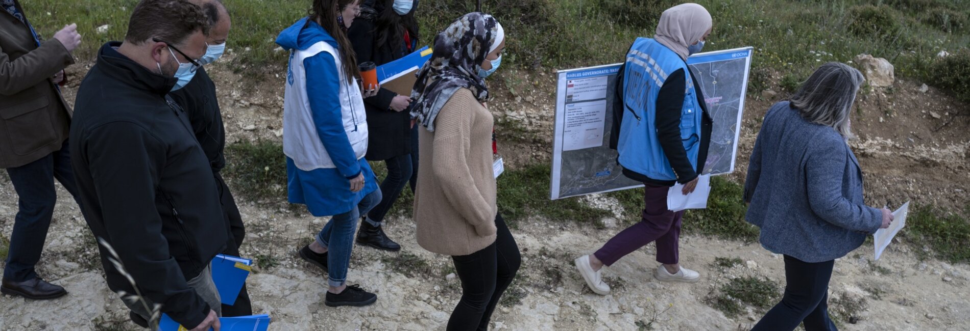 OCHA staff and others walking near the Palestinian villages of Yasuf and Madana, the West Bank, April 2021. Photo by Tanya Habjouqa/LWD for OCHA