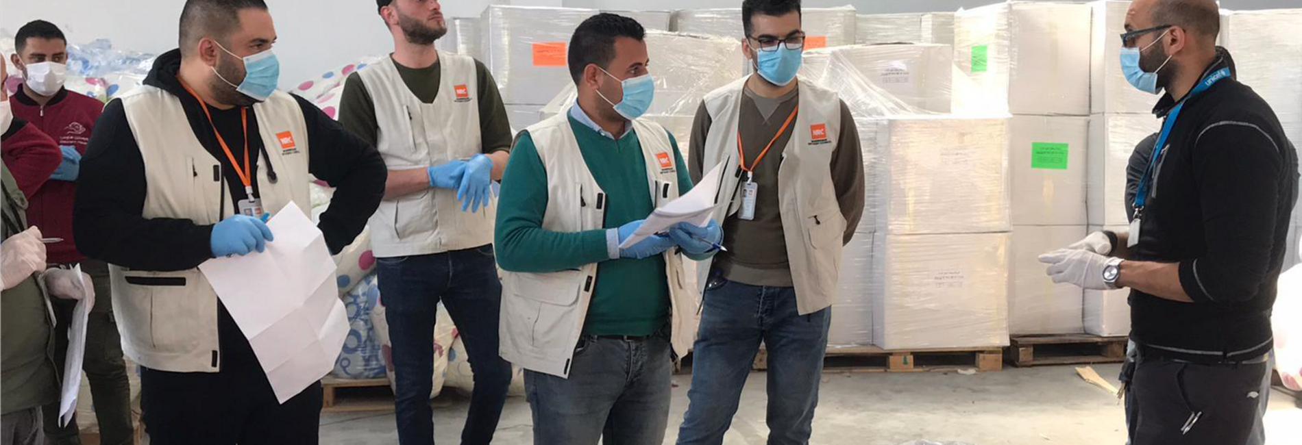 Staff of an aid organization preparing for the distribution of bedding sets to isolation centers. April 2020, Rafah. Photo by NRC